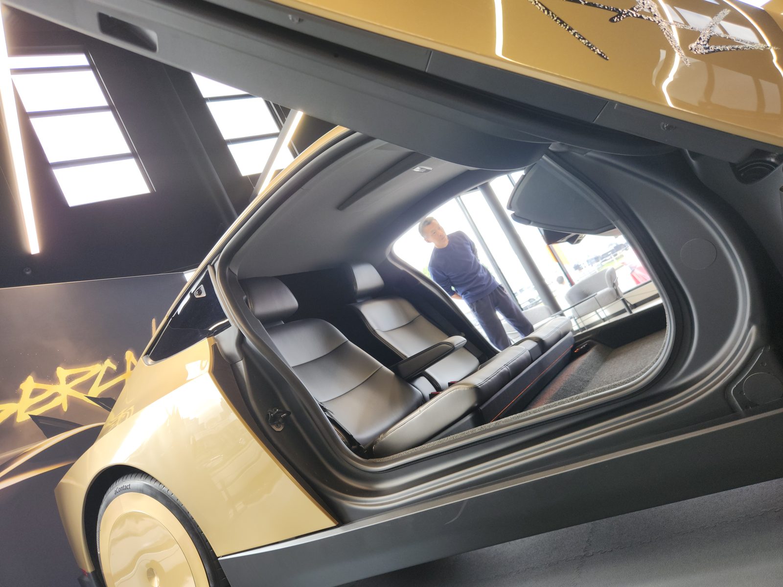Cabin through open Cybercab butterfly door showing two seats and no steering wheel or pedals