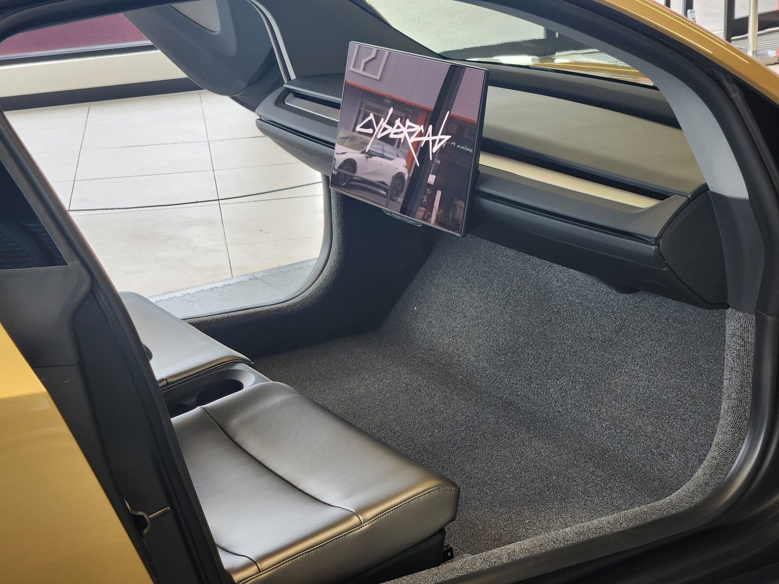 Cybercab interior with centre CYBERCAB screen and open footwell, no pedals