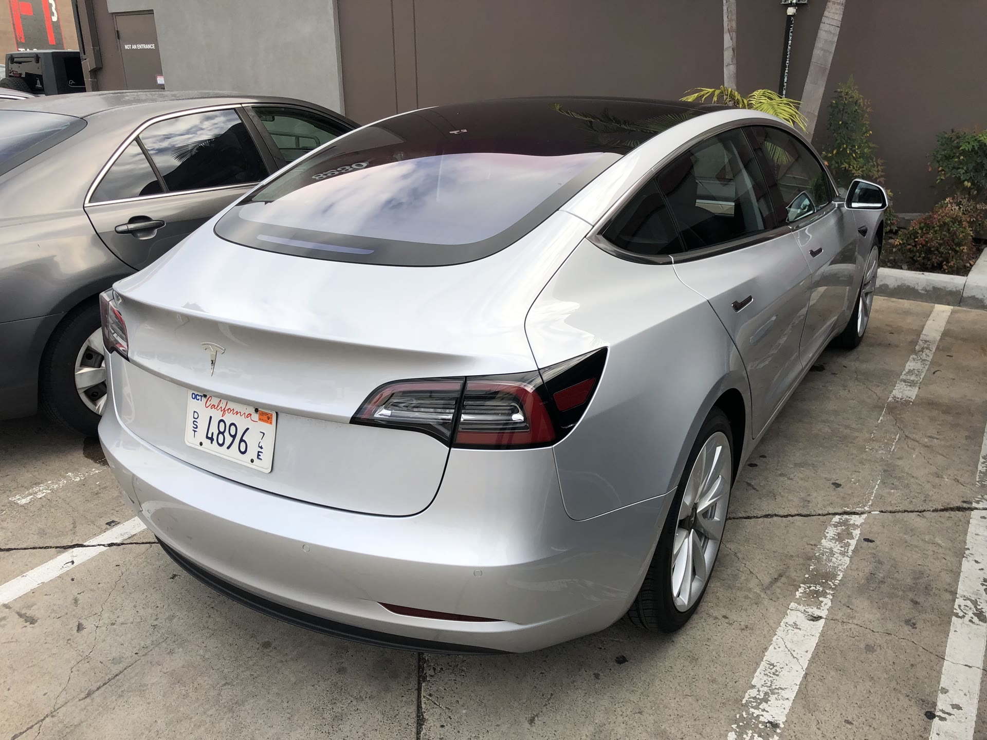 Silver Tesla Model 3 parked outdoors, 2018